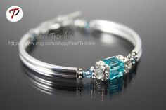 ------------- Swarovski turquoise cube crystal hugged by Swarovski squaredelles  Double silver-plated curved tubes Antiqued silver plated bead spacers Silver plated toggle clasps, rings, wire protectors Beading Wire Length is about 7.25 inches but can be customized.  With matching earrings sold separately @ https://www.etsy.com/listing/214260552/light-blue-crystal-earrings-turquoise?ref=shop_home_active_15 Thank you for visiting my shop!Comes in elegant jewelry box ready for gift-giving! Blue Stackable Jewelry As Gift, Elegant Blue Stackable Crystal Bracelet, Adjustable Blue Crystal Bracelet For Anniversary, Turquoise Sterling Silver Bracelets For Anniversary, Turquoise Sterling Silver Bracelet For Anniversary, Elegant Turquoise Birthstone Bracelets, Personalized Blue Sterling Silver Bracelets, Turquoise Crystal Bangle Bracelet As Gift, Turquoise Bangle Crystal Bracelet For Gift