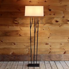 the floor lamp is made out of metal and has a square light shade on it