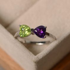 This ring features two 6*6mm heart cut genuine amethyst and peridot and sterling silver finished with rhodium. Customization is available. It is made by hand, and it will take about 7 days to finish the ring after your payment is completed. Main stone: natural amethyst, natural peridot Peridot Birthstone Ring In White Gold, Green Sterling Silver Amethyst Ring For Wedding, Green Amethyst Sterling Silver Ring Gift, Green Amethyst Ring With Accent Stones For Promise, Green Amethyst Promise Ring With Accent Stones, Green Amethyst Ring With Center Stone For Anniversary, Amethyst Promise Ring For May Birthstone, Green Heart-cut Birthstone Ring As Gift, Green Heart Cut Birthstone Ring For Gift