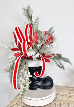 a christmas arrangement in a boot on a table