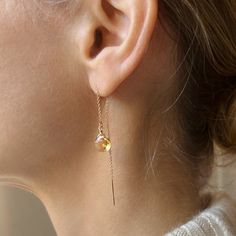 Our dainty citrine thread earrings are the perfect lightweight everyday earring. As simple as they are, the dangling sparkling citrine gemstone really makes a statement. They make a great birthstone earring gift as we offer a choice of every month's birthstone as well as other popular gemstones in the drop-down menu. We also offer these earrings in gold filled, sterling silver, rose gold and 14k gold. The model is wearing the citrine November birthstone earrings. CRAFTSMANSHIP  Jewelry is handmade by us in our NYC studio. We focus on craftsmanship and quality using only the highest quality materials and handpicked genuine gemstones.  PACKAGING We take pride in creating beautifully packaged orders. Jewelry arrives delicately wrapped in tissue and placed in a kraft box inside a logo drawstri Nyc Studio, Citrine Jewelry, Citrine Earrings, Thread Earrings, Birthstone Earrings, Earring Gift, Earrings In Gold, November Birthstone, Birthstone Earring