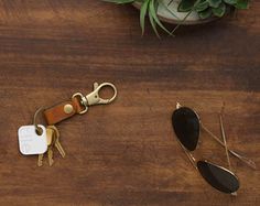 a wooden table topped with lots of different types of keychains and other items