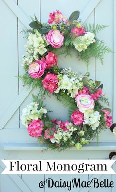 a floral wreath on the side of a door with pink and white flowers in it