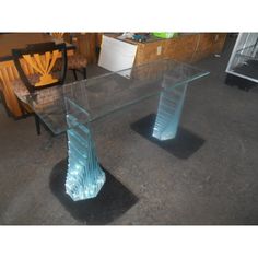 two glass tables sitting on top of a floor next to each other in a room