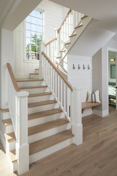 there is a white staircase with wooden handrails in the room and wood flooring