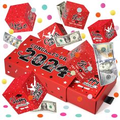 a red box filled with money sitting on top of a table covered in confetti