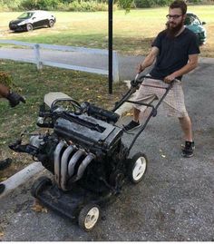 a man pushing a lawn mower with an engine on it