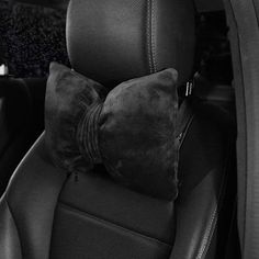 a black and white photo of the back seat of a car with a pillow on it