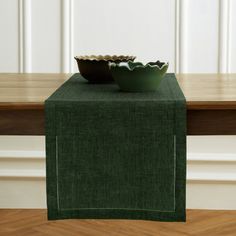 two bowls are sitting on a table with a green cloth draped over the placemat