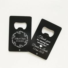 two black bottle openers with wedding date printed on the front and back one has a heart