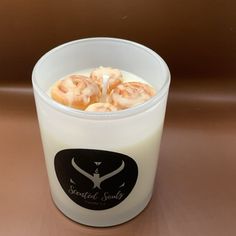 a glass filled with food sitting on top of a table next to a brown wall