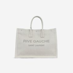 Acclaimed for its minimalist silhouettes, the Rive Gauche tote from Saint Laurent is the ideal accessory for any woman with a chic, simple sense of style and a love for luxury. Crafted from light grey/beige canvas and dark grey lettering, the bag is large enough to carry around everything with you for a day of errands or shopping. SPL Exterior Light grey/beige canvas exterior Grey lettering Silver hardware Two black leather top handles Unused - tiny mark due to storing Interior Canvas interior One compartment One zip pocket Unused Sold on its own SPL Height 36cm Width 48cm Depth 16cm Black Leather Top, Grey Beige, Rive Gauche, Dior Shoes, Timeless Handbag, Grey And Beige, Luxe Fashion, Exclusive Bag, Chanel Handbags