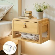 a nightstand with books on it next to a bed and flowers in a vase sitting on top of the night stand