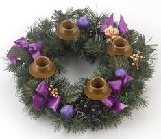 a christmas wreath with pine cones and purple bows