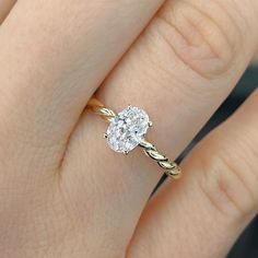 a woman's hand with a diamond ring on top of her finger and an engagement band