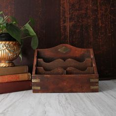 an old wooden box with two books and a potted plant