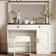 a white dressing table with mirror, stool and light bulbs on the wall above it