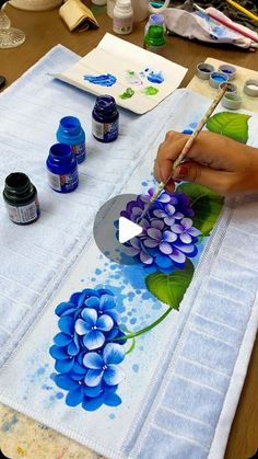 a person is painting flowers on a table