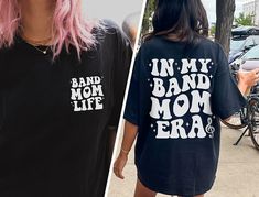 "✦ 🇺🇸SENT TO PRODUCTION AND PRINTED IN THE US🇺🇸 ✦The perfect In My Band Mom Era Graphic TShirt is yours!  ✦ QUICK FACTS ✦ Comfort Colors® C1717 T-Shirt is 100% ringspun cotton (ringspun=comfort) Preshrunk, soft washed, garment-dyed fabric Twill-taped back neck and shoulders ✦ SIZING TIPS ✦ All our garments are UNISEX.  FOR AN OVERSIZED LOOK, SIZE UP 2-3 SIZES For a Relaxed Fit order your Usual Size For a Snug Fit order 1 Size down If you're unsure: Lay your favorite fitting T-Shirt flat and *measure armpit to armpit (1\" under armpit) for width *measure from point where neck seam meets shoulder all the way to bottom for length & compare with measurements in Size Chart provided in each listing *Please note, Size Chart Measurements are to be used as guidelines and measurements may vary w Band Merch Shirt With Slogan For Fans, Band Merch Slogan Shirt For Fans, Letter Print Shirt For Concerts And Music Festivals, Band Merch Shirt With Text Print For Concert, Band Merch Shirt With Slogan For Concerts, Band Merch Shirt With Slogan, Cotton Slogan Shirt For Concert, Band Mom Shirts, Band Mom