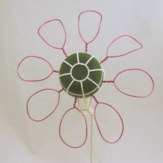 a green and white object with red wires attached to it's centerpieces