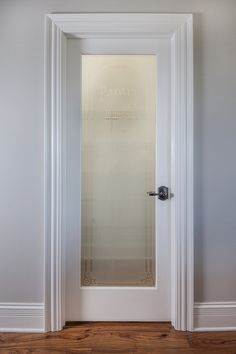 an empty room with a glass door and wood flooring in front of the doorway