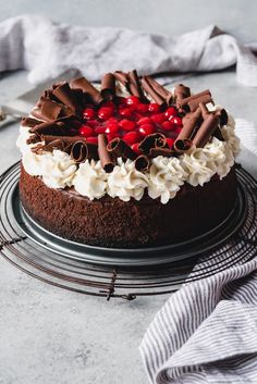 a chocolate cake topped with cherries and whipped cream