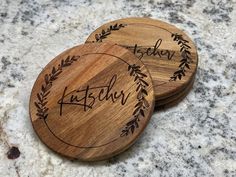 two personalized wooden coasters sitting on top of a granite countertop with the word baby written in cursive writing