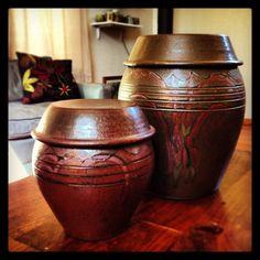 two brown vases sitting on top of a wooden table next to a couch in a living room