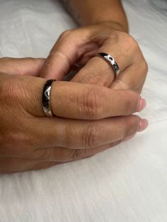 two hands holding each other while wearing wedding rings