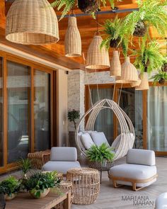 an outdoor living area with wicker furniture and hanging plants