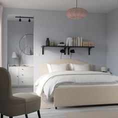 a bedroom with a bed, chair and shelves on the wall above it's headboard