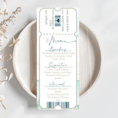 a white and blue wedding program on a plate