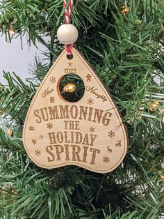 a wooden ornament hanging from a christmas tree with the words, summoning the holiday spirit