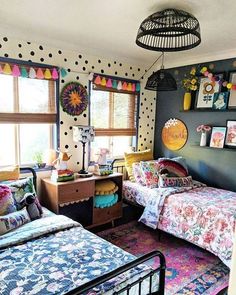 two beds in a room with polka dots on the walls and colorful decor around them