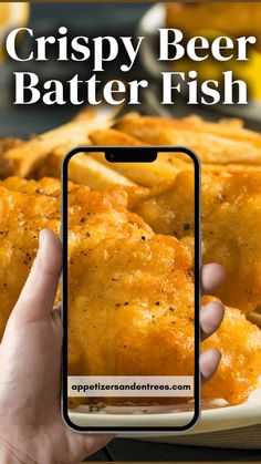 a person holding up a cell phone to take a photo of crispy beer batter fish