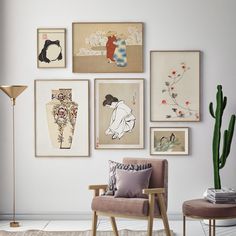 a living room filled with lots of art on the wall above a chair and table