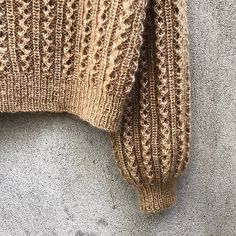 a brown sweater hanging on the side of a wall