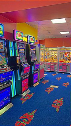 an arcade filled with lots of machines and colorful carpeted flooring on top of it