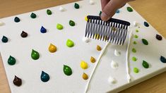 a person using a comb to cut up jelly beans on a board with plastic forks