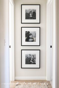 three black and white photos hang on the wall above a rug in a hallway with an open door