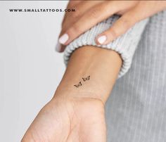 a woman's wrist with a small butterfly tattoo on her left hand and the word love written across it