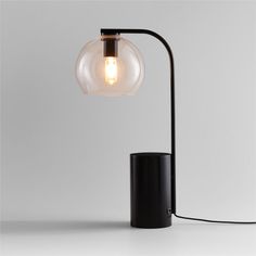 a black table lamp with a light bulb on it