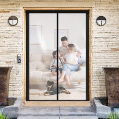 a man and two children sitting on a couch in front of a sliding glass door