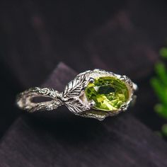 "Take a glimpse at this magical piece of nature-inspired jewelry. This green solitaire ring, adorned with graceful leaves, features a stunning peridot gemstone set in sterling silver. It's the perfect choice for a romantic gift, capturing the beauty of nature in an exquisite leaf gemstone ring. DETAILS: Stone - 8*6mm Natural Peridot Metal - recycled solid Sterling Silver Dimensions - width 9mm (0.35 in.), band width - 2.5mm (0.098 in.) Finish - shiny  (oxidized at your request) HOW TO ORDER ▪   Simply choose your ring size and a gemstone in dropdown menus. ▪   Add an engraving you'd like to have inside in the 'Personalization Box' (optionally). ▪   Feel free to contact me if you want to change anything about the ring design (dimensions, additional stones, material etc.) ADDITIONAL INFORMAT Nature-inspired Emerald Ring For May Birthstone, Nature-inspired Green Emerald Ring For May Birthstone, Nature-inspired May Birthstone Jewelry, Nature-inspired Emerald Promise Ring, Nature-inspired Green Emerald Gemstone Ring, Nature-inspired Emerald Ring, Green Peridot Rings With Nature-inspired Style, Nature-inspired Green Emerald Ring For Anniversary, Nature-inspired Green Emerald Anniversary Ring