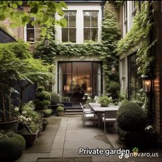 an outdoor dining area with potted plants on the wall and tables in the middle