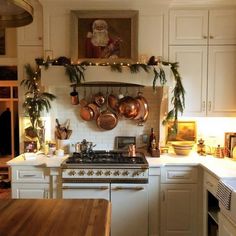 a kitchen with an oven, stove and counter top in the center is decorated with pots and pans