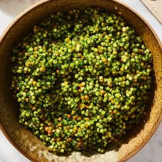 a bowl filled with green peas on top of a table