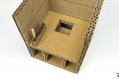 an open cardboard box with a small square hole in it