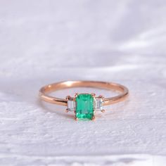 "Rectangular Cut Emerald Three Stone Ring with Baguette Cut Diamonds / Baguette Cut Emerald Ring / 14K Rose Gemstone Ring Our designs are based on colors of life and each color identifies a motion, a feeling, an emotion and style in each person's life. Through time, Emerald Stone has been known as a symbol of truth and love with its unique Green Color. In ancient Greece and Rome, Emerald was said to be the Gemstone of the Goddess Venus, purveyor of love and hope. On the other side of the world, Square Cut Emerald Ring With Accent Stones For Wedding, Wedding Jewelry With Baguette Diamonds In Rectangular Setting, Wedding Jewelry With Baguette Diamonds, Timeless Square Cut Emerald Ring For Weddings, Wedding Emerald Ring With Square Cut, Timeless Square Cut Emerald Wedding Ring, Exquisite Rectangular Wedding Rings, Three Stone Rectangular Diamond Jewelry, Rectangular Three Stone Diamond Jewelry