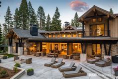 a large house with lots of furniture in front of it and trees around the yard